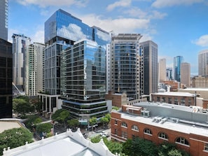 A modern urban skyline with high-rise buildings, including a distinctive glass structure and a cylindrical building.