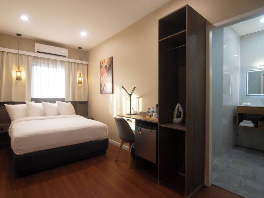 Ein Hotelzimmer mit Bett, Schreibtisch, Stuhl und Spiegel.