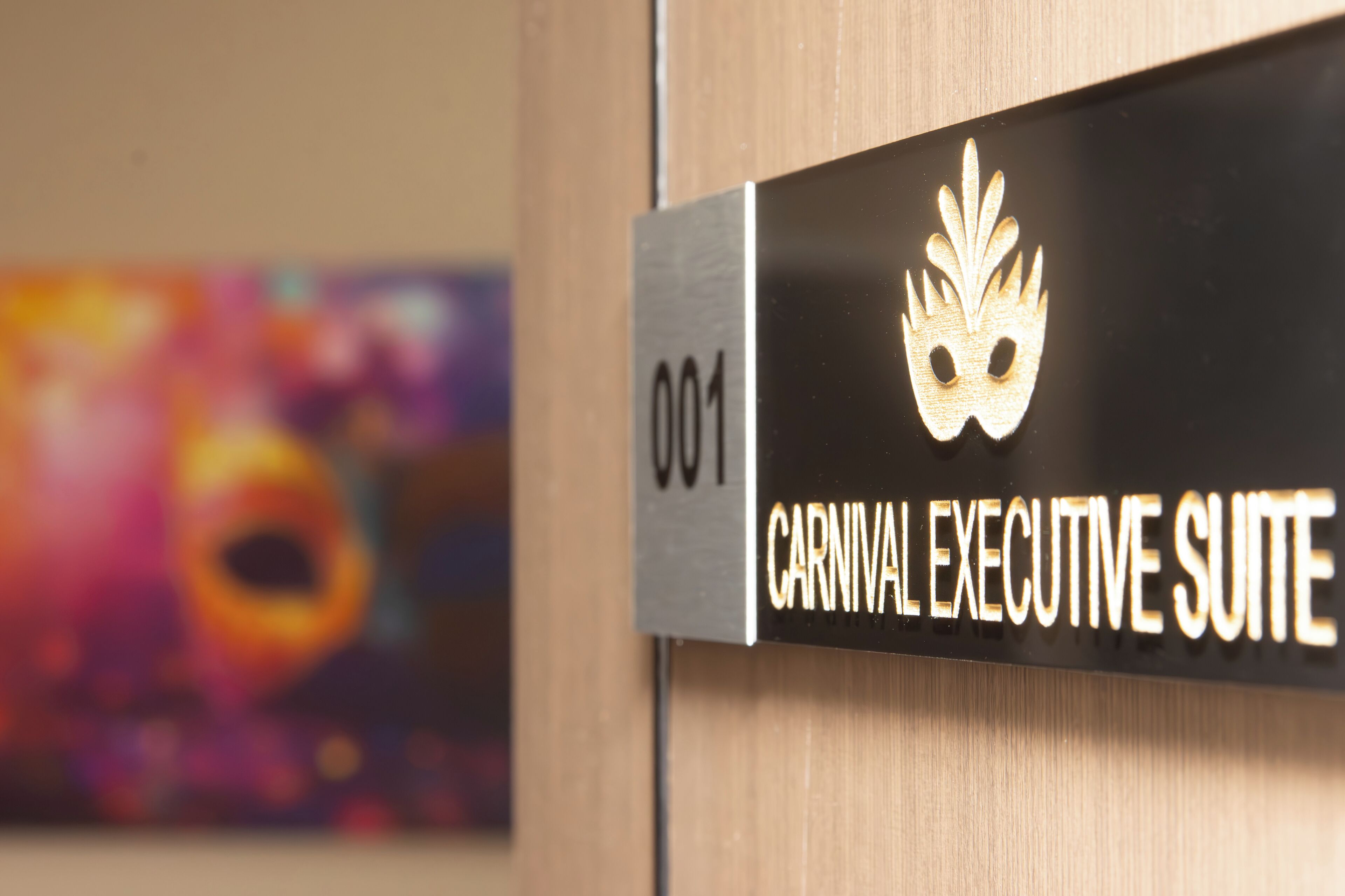 A sign for the "Carnival Executive Suite" with a gold mask emblem.