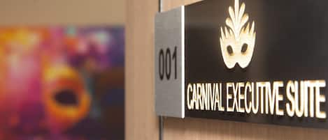 A sign for the "Carnival Executive Suite" with a gold mask emblem.