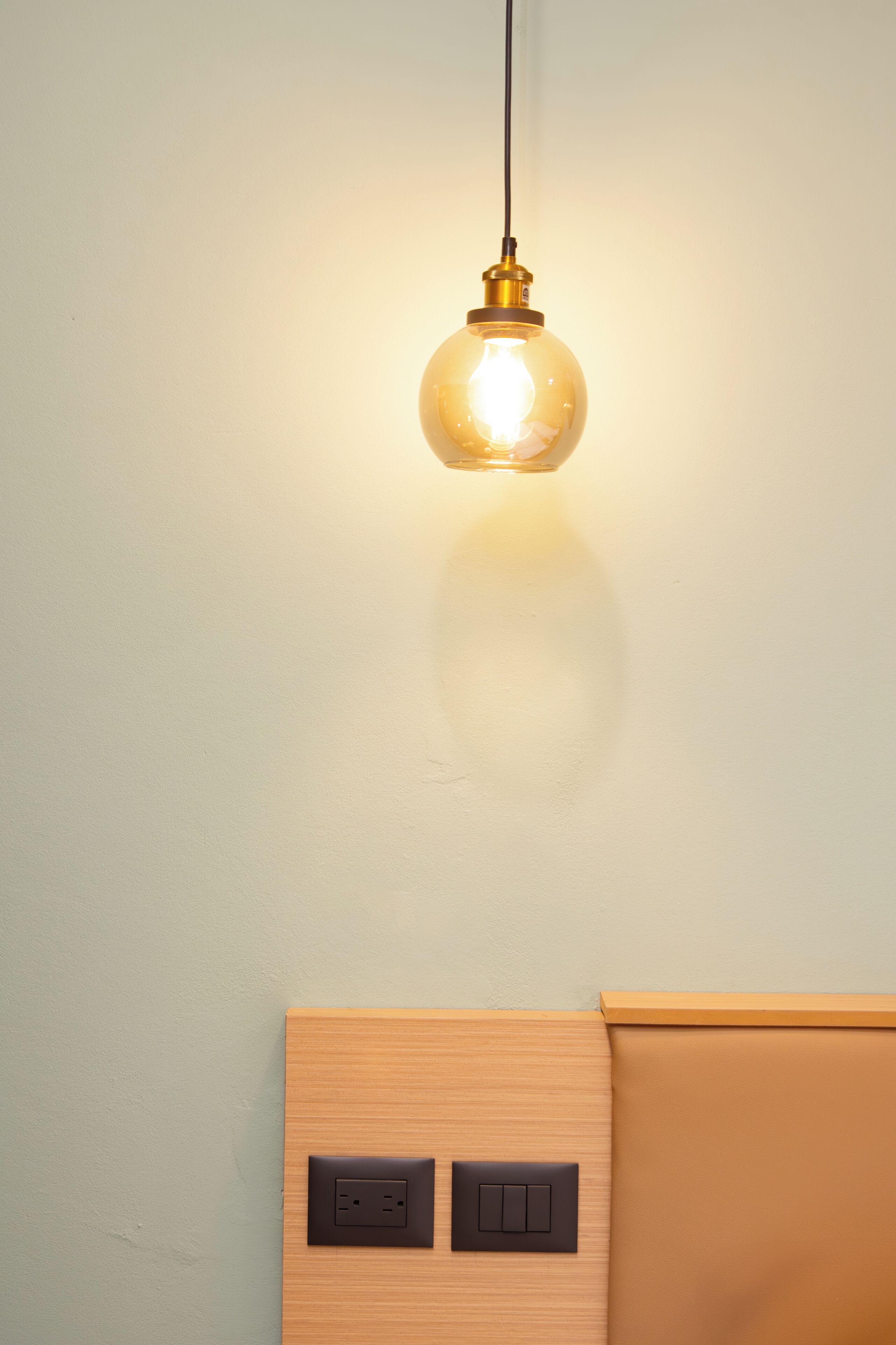 A light fixture with a spherical glass shade and a switch below it.