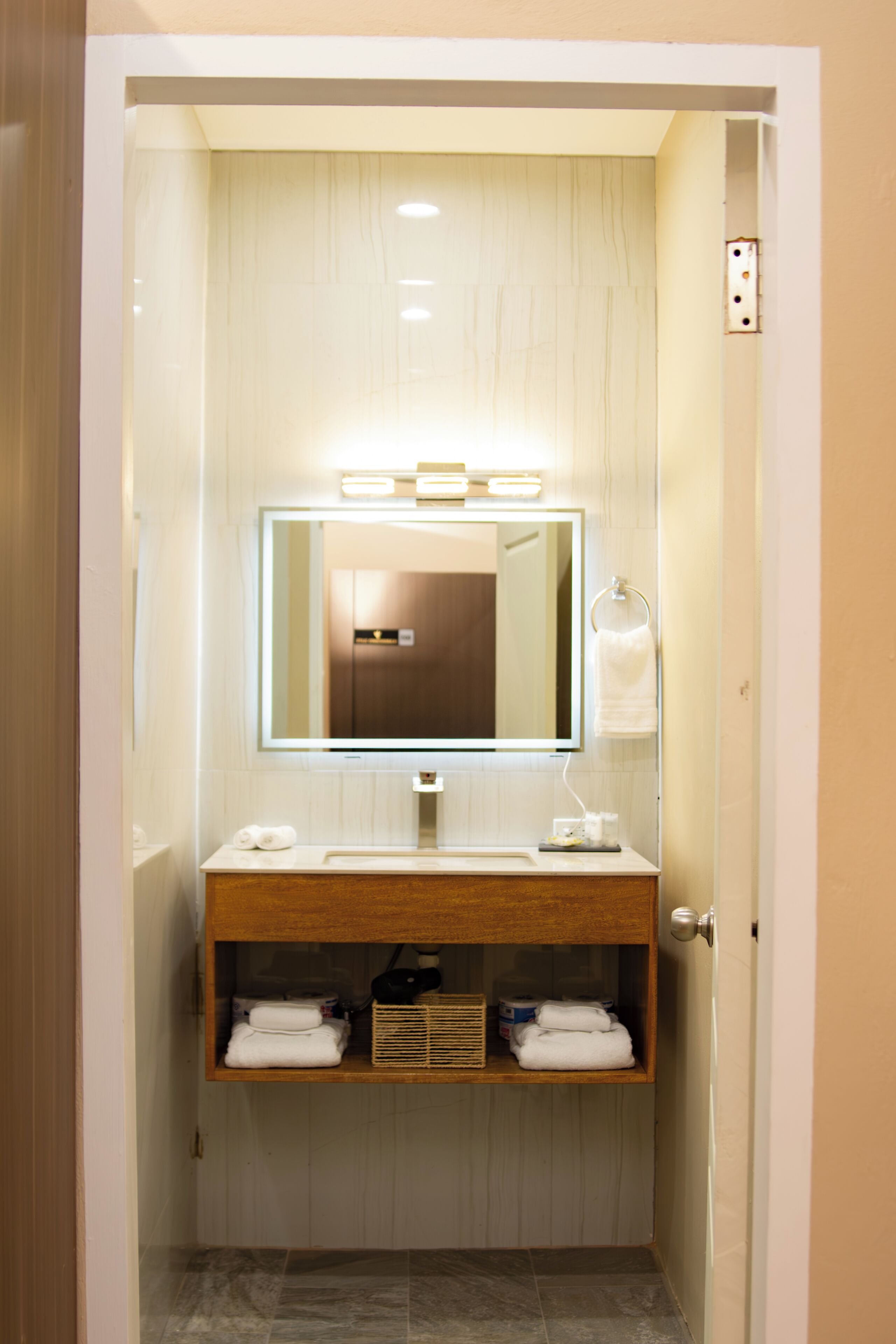 Une salle de bain avec un miroir, un lavabo et un porte-serviettes.