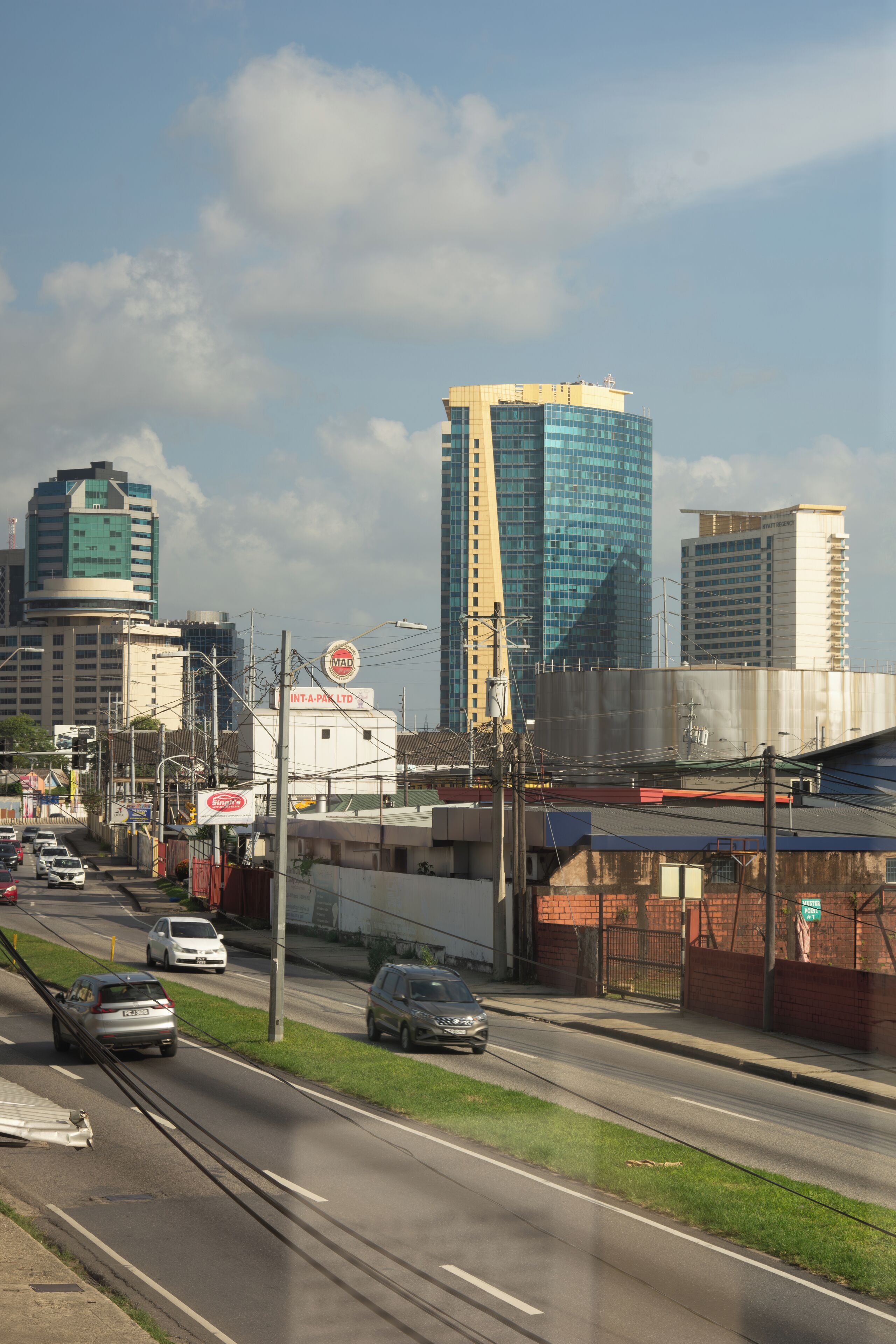 A cityscape with modern buildings, a busy road, and a clear sky.