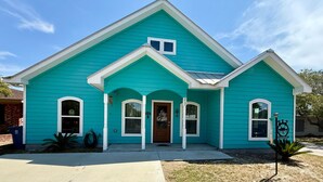 A two-story house with a teal exterior, white trim, and a front porch. - Coastal Comfort Retreat | Near Beach | Sleeps 10! (Rockport)