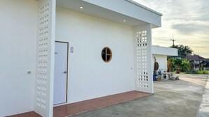 A building with a white exterior, a door, and a small window. - Nakai resort Sakon Nakhon (Sakon Nakhon)