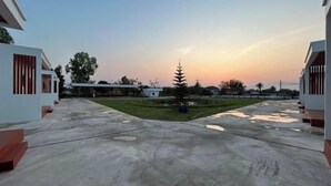 A spacious courtyard with a central tree, surrounded by modern buildings with large windows and a flat roof. - Nakai resort Sakon Nakhon (Sakon Nakhon)