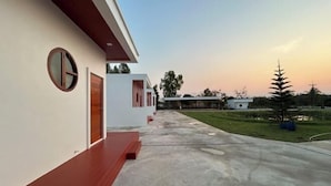 A modern building with a flat roof, a circular window, and a wooden door. - Nakai resort Sakon Nakhon (Sakon Nakhon)