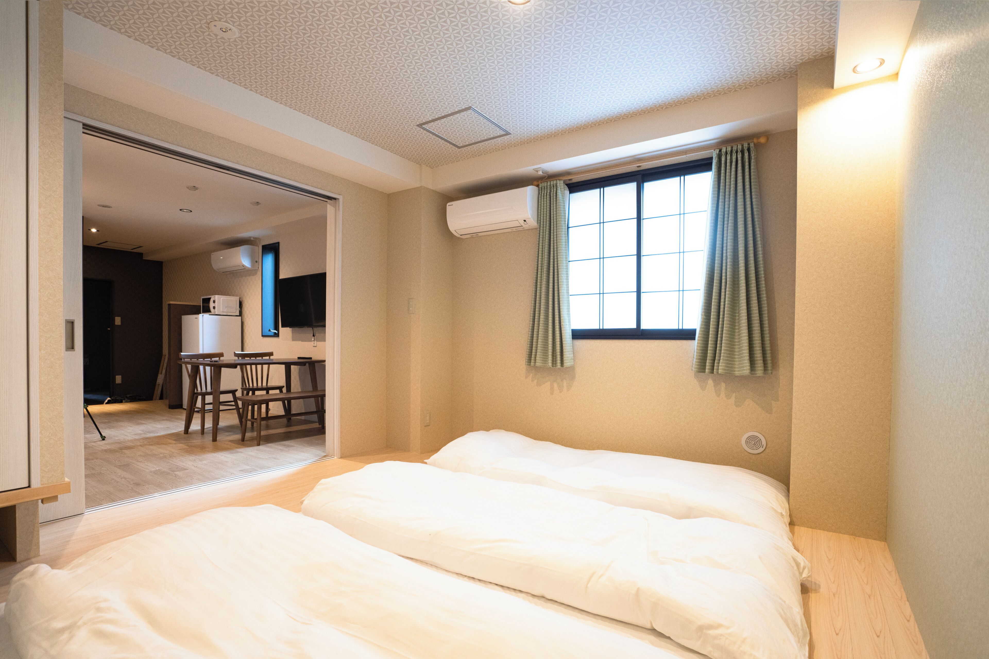 A hotel room with a bed, a desk, and a television.