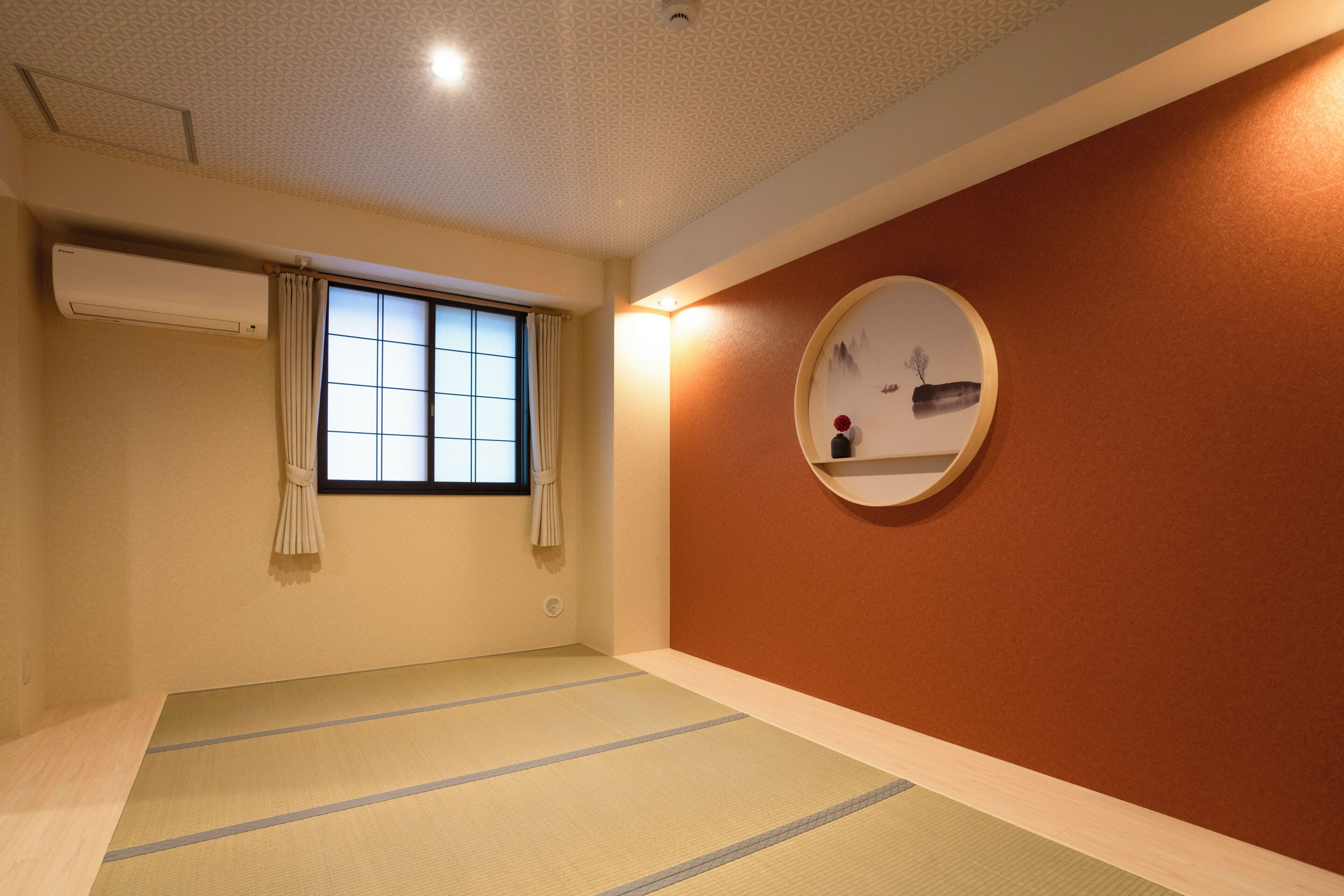 Una stanza con pavimento in tatami, finestra con paravento shoji, condizionatore d'aria e mensola a parete con un vaso.