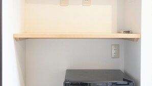 A flat-screen TV mounted on a wall above a wooden shelf. - Tokyo Biyori Hotel (Tokyo)