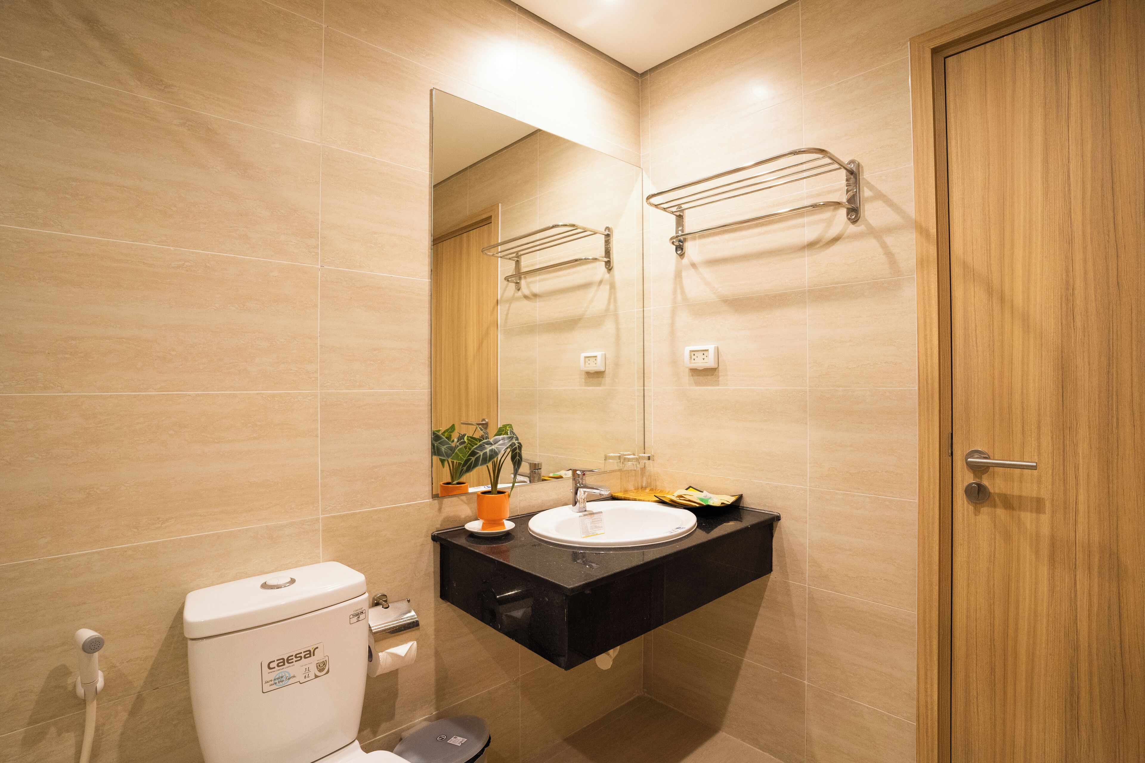 A modern bathroom with a toilet, sink, and mirror.
