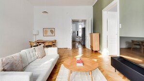 A modern living room with a sofa, coffee table, and a TV stand.