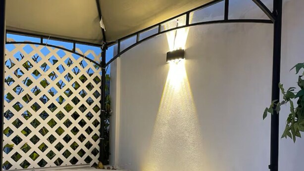 A hot tub under a canopy with a lattice wall and a wall-mounted light. - Charming 1-bedroom cabin in Unidad habitacional Santa Teresa with jacuzzi (Unidad habitacional Santa Teresa)