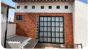 A modern building with a tiled roof, a large garage door, and a small balcony. - Charming 1-bedroom cabin in Unidad habitacional Santa Teresa with jacuzzi (Unidad habitacional Santa Teresa)