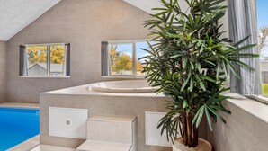 Ein modernes Badezimmer mit einer Badewanne, einer Dusche und einem großen Fenster.