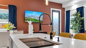 A modern kitchen with a white countertop, a built-in sink, and a stainless steel faucet. - Houston Getaway I Near NRG, Downtown, Airport (Houston)