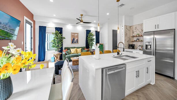A modern kitchen with a central island, stainless steel appliances, and a dining area with a sofa and coffee table. - Houston Getaway I Near NRG, Downtown, Airport (Houston)