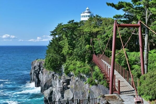 Un pont côtier avec un phare en arrière-plan.