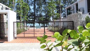 A modern building with a stone wall and a metal gate. - Modern Condo Walk to Rawai Beach C188 (Rawai)