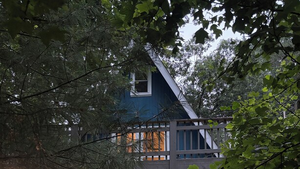 A two-story wooden house with a wooden staircase leading to a deck. - Cozy 2-bedroom tiny cabin with roomy loft, AC, and fire pit near Bryce Resort (Mount Jackson)
