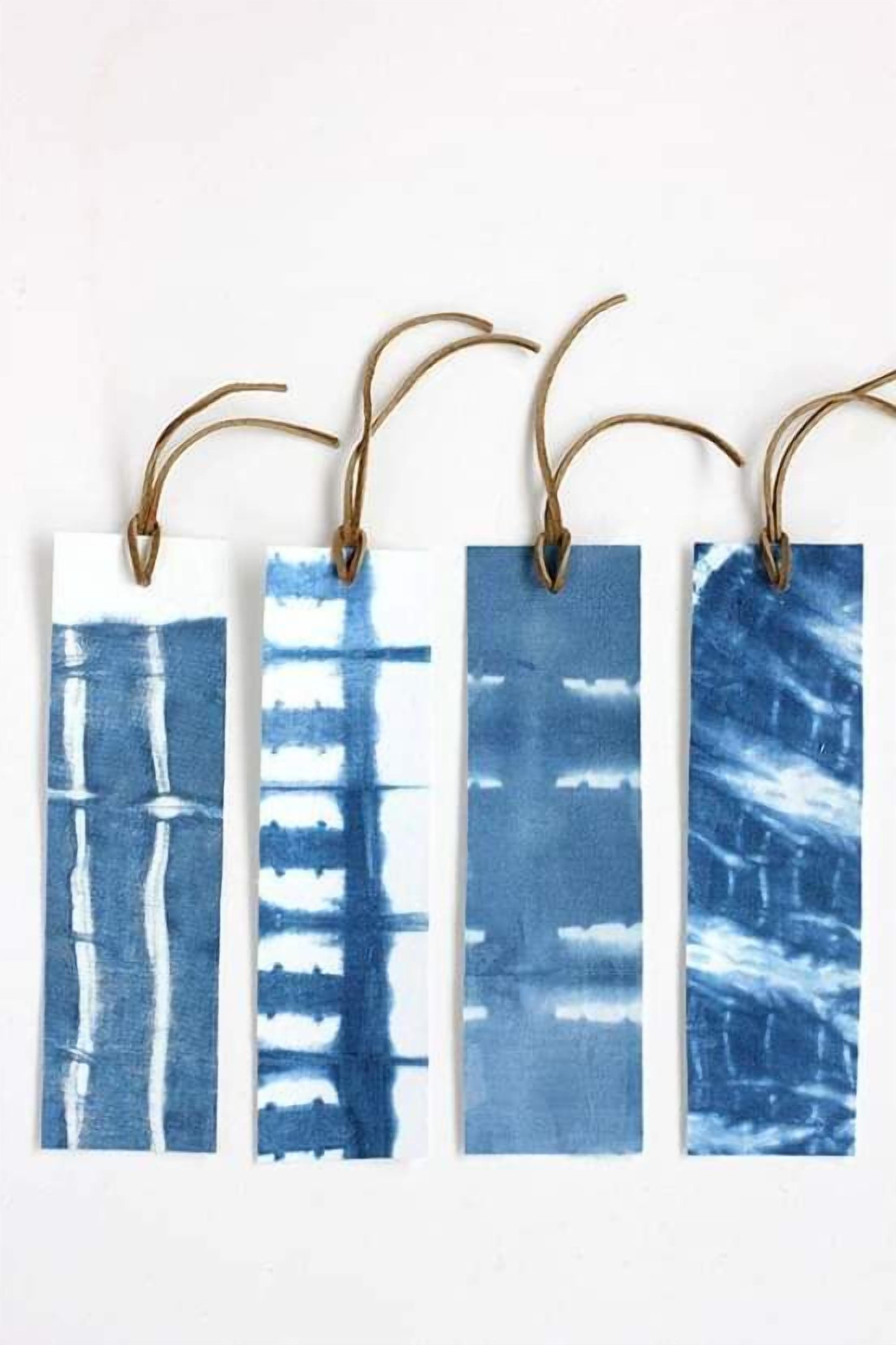Four rectangular tags with blue abstract designs, each hanging from a brown cord.