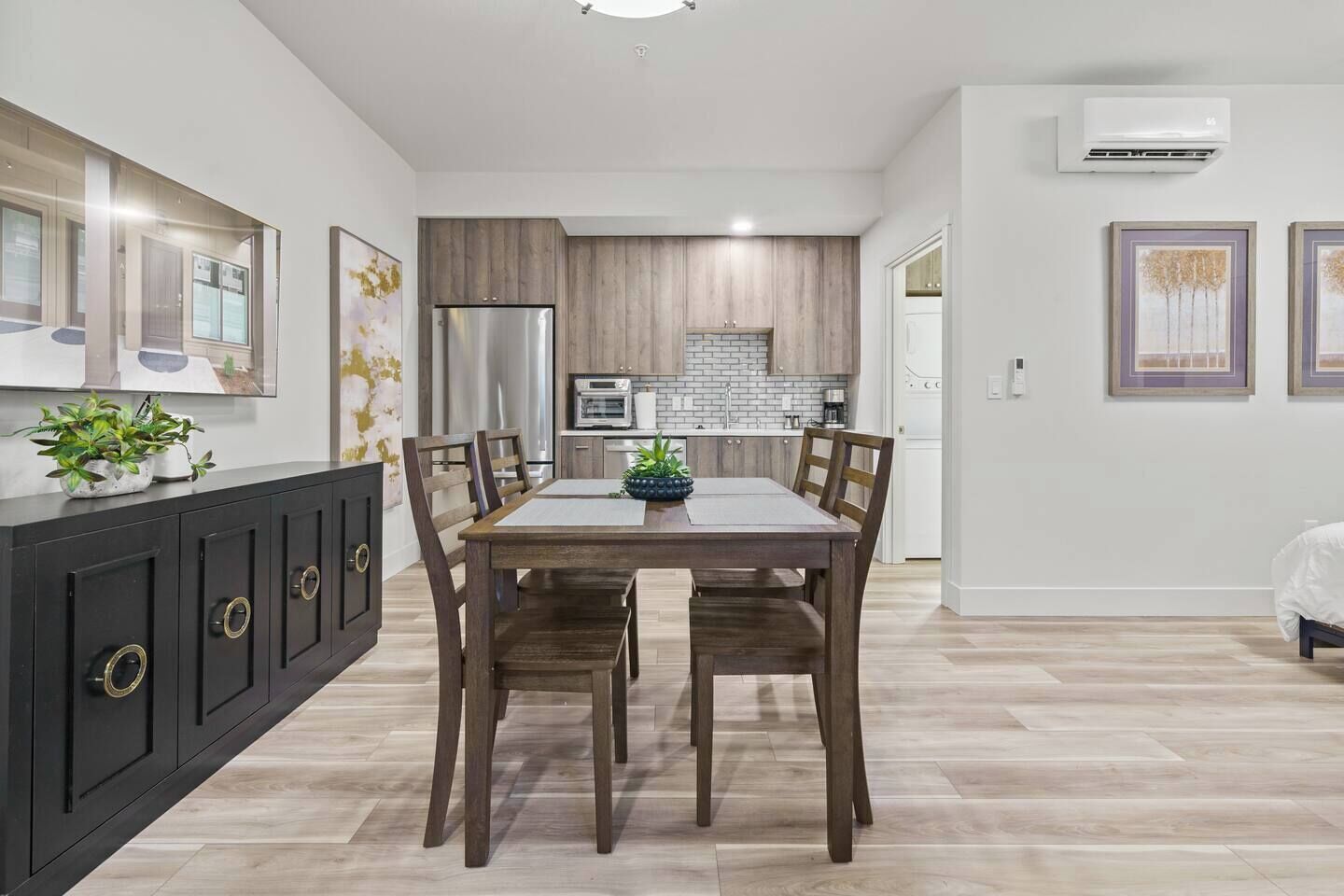 A modern kitchen with wooden cabinets, a stainless steel refrigerator, and a built-in oven.