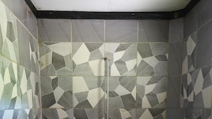 A shower area with geometric patterned tiles and a drain. - White Sandy Beach Eco Lodge (Naviti Island)