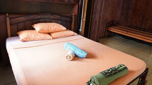 A single bed with a wooden headboard, a bench, and a door in a room with wooden paneling. - White Sandy Beach Eco Lodge (Naviti Island)