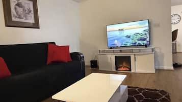 Älytelevisio, pöytätennispöytä, kirjoja, tulostin