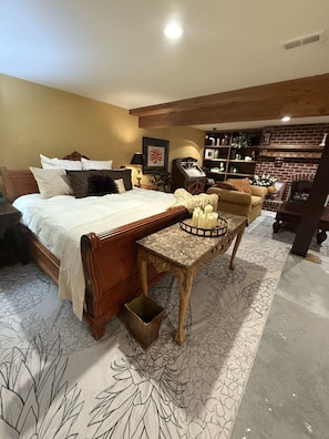 A bedroom with a bed, bedside table, and a small table with candles.