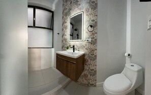 Een douche, handdoeken, zeep, toiletpapier
