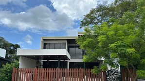 A modern two-story house with a covered patio and a decorative gate. - Amazing 3-bedroom apartment with AC in Tamarindo (Tamarindo)