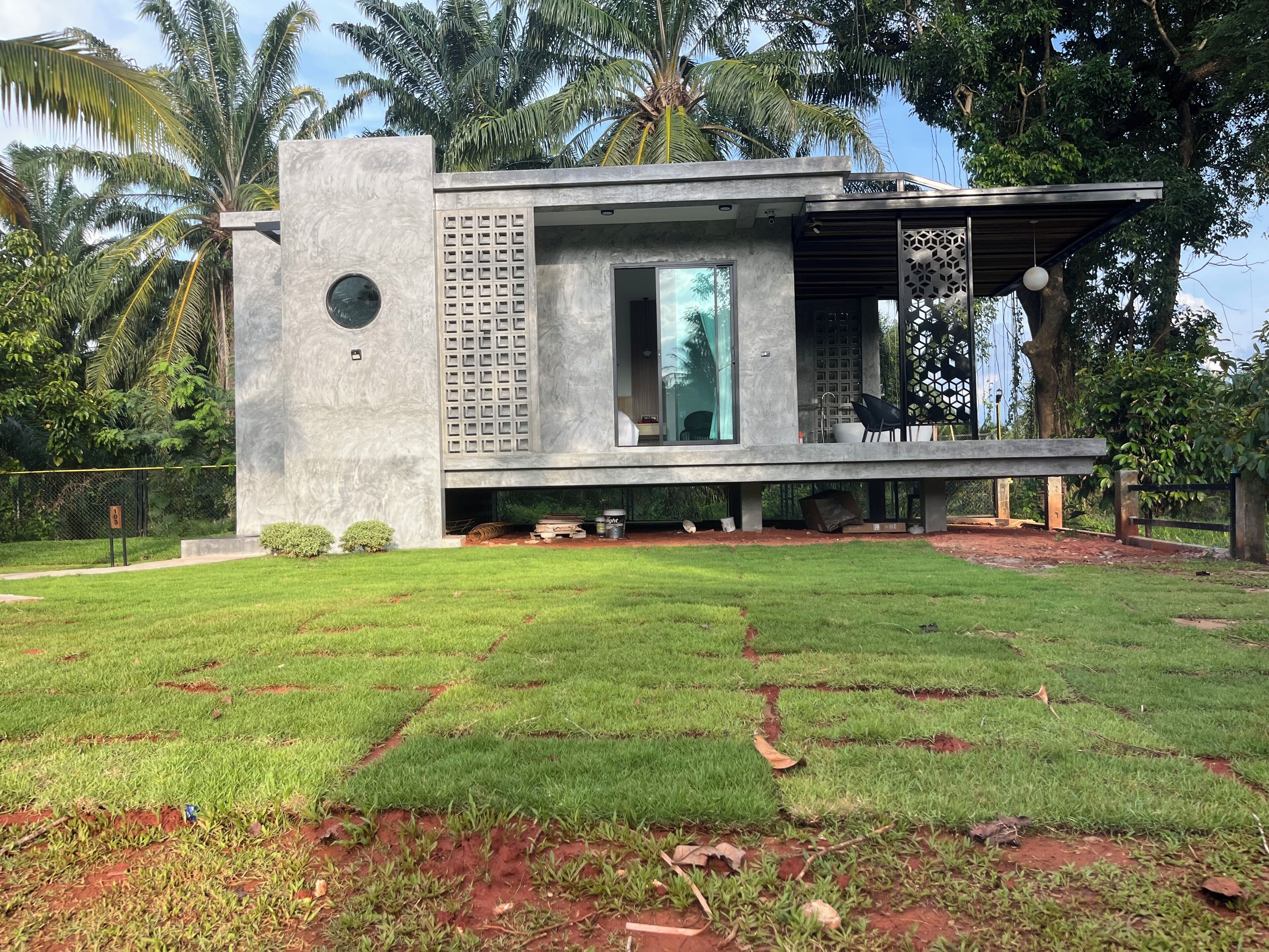 Una casa moderna con techo plano, ventanas amplias y fachada de concreto.