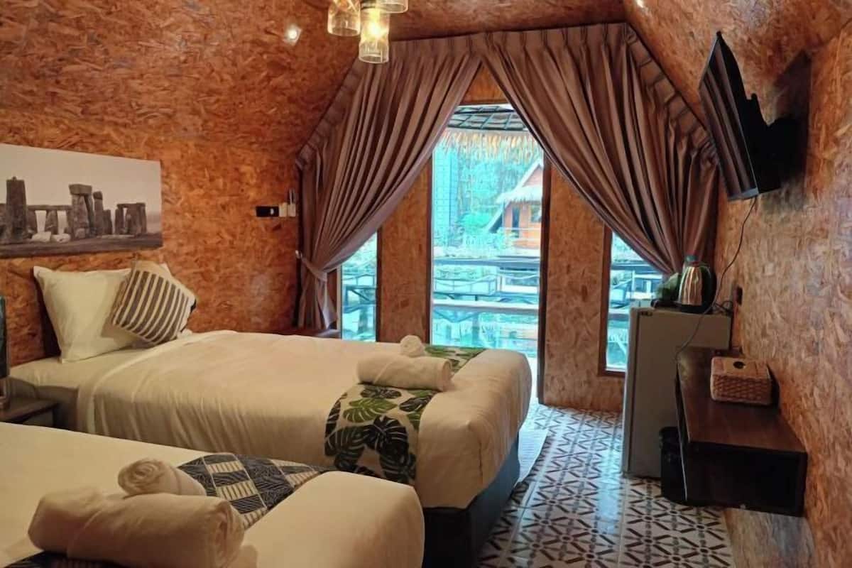A cozy room with a bed, a small table, and a TV mounted on the wall.
