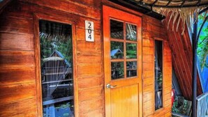 A wooden cabin with a number '204' on the door, a glass window, and a thatched roof. - Koyad resort (Nakhon Si Thammarat)