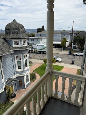 Un quartier résidentiel où se trouve une maison dotée d’une tourelle et d’un balcon agrémenté d’une balustrade.