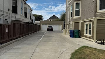 En boligvej med huse, en garage og en parkeret bil.