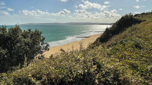A coastal landscape with a beach, vegetation, and a clear sky. - 3 bedroom accommodation in Westbourne, near Bournemouth (Westbourne, near Bournemouth)