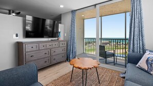 A modern living room with a flat-screen TV, a wooden coffee table, and a sofa. - Spectacular Ocean Views at Beach and Tennis 4705 (Bonita Springs)