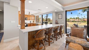A spacious kitchen with wooden cabinets, a white countertop, and a view of the outdoors.