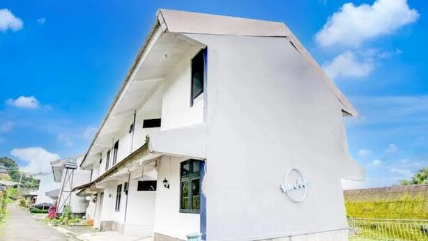 Een modern huis met twee verdiepingen, een schuin dak, een zichtbare garage en een verharde oprit.