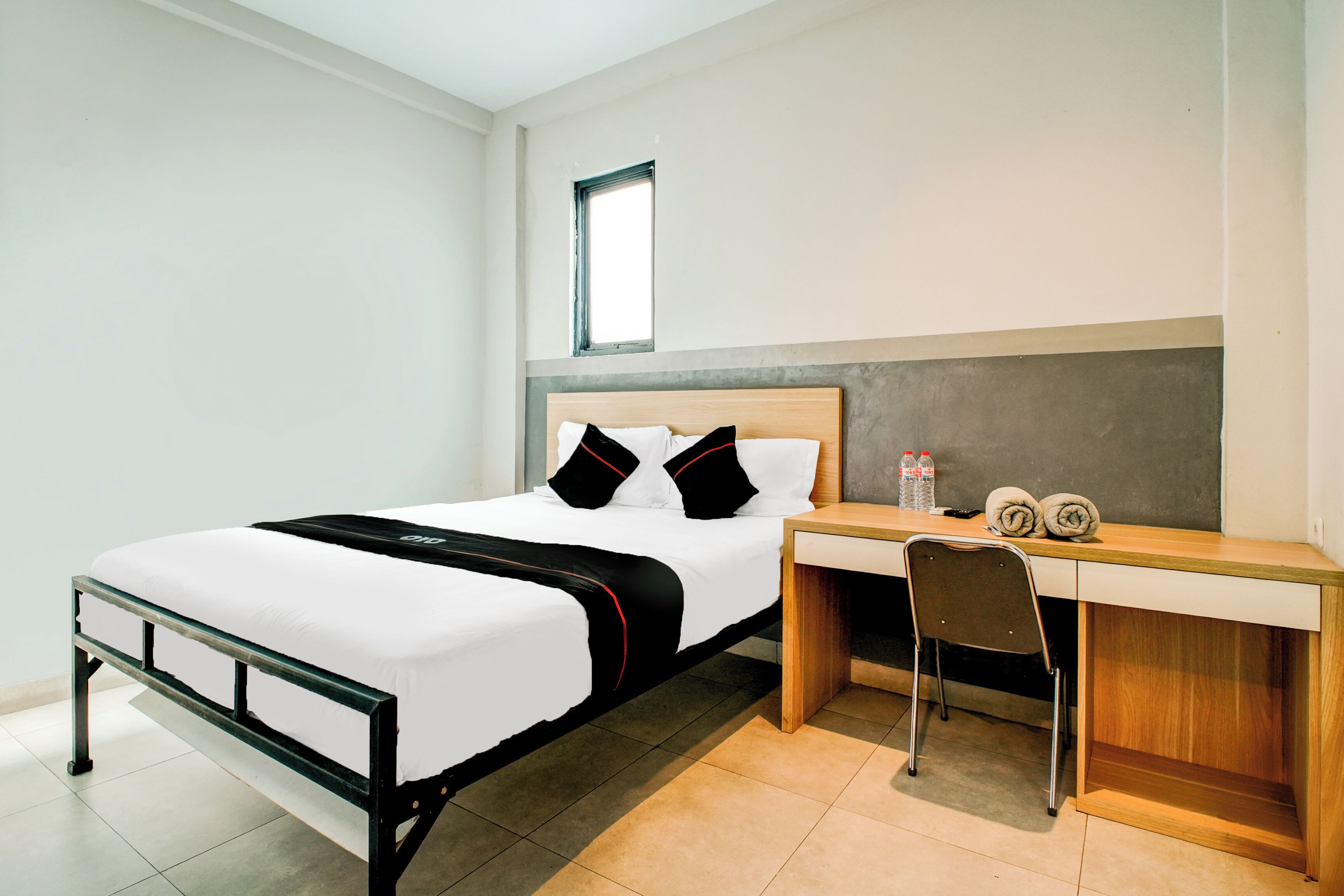 Une chambre d’hôtel avec un lit, un bureau et une chaise.