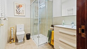 A modern bathroom with a glass-enclosed shower, a toilet, a sink, and a vanity.