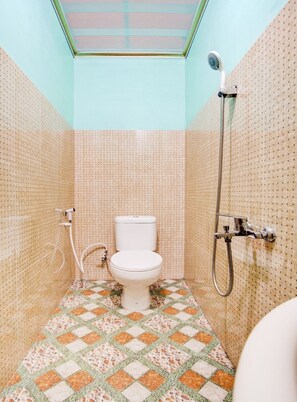 Un baño pequeño con inodoro, ducha y tragaluz.