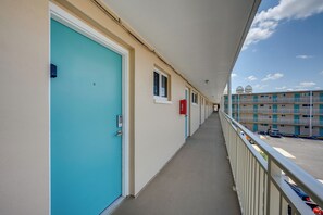 A corridor with doors, a fire alarm, and a view of a parking area. - Oceanfront Gem - Walk to Daytona Beach Pier! (Daytona Beach)