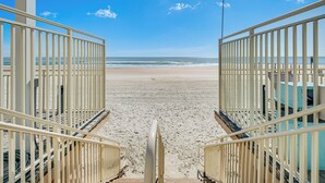A beach view with a railing in the foreground and a clear sky. - Oceanfront Gem - Walk to Daytona Beach Pier! (Daytona Beach)