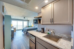 A compact kitchen with a built-in microwave, a coffee maker, and a sink. - Oceanfront Gem - Walk to Daytona Beach Pier! (Daytona Beach)