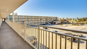 A balcony with a view of a parking lot and a multi-story building with balconies. - Oceanfront Gem - Walk to Daytona Beach Pier! (Daytona Beach)