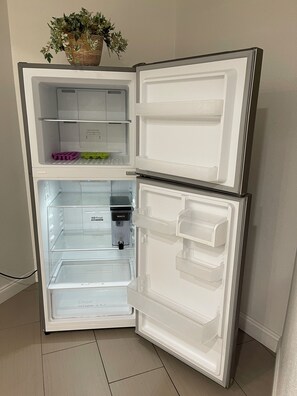 Un refrigerador con dos compartimentos de puerta, un dispensador de agua y un compartimento congelador.