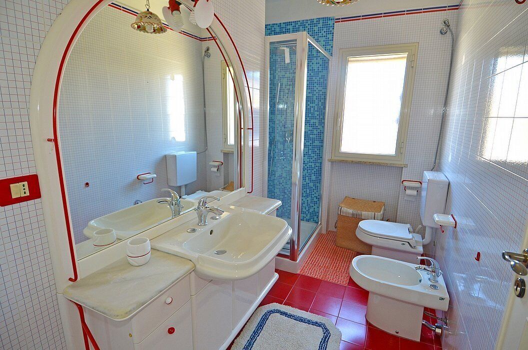 A bathroom with two sinks, a toilet, and a shower.